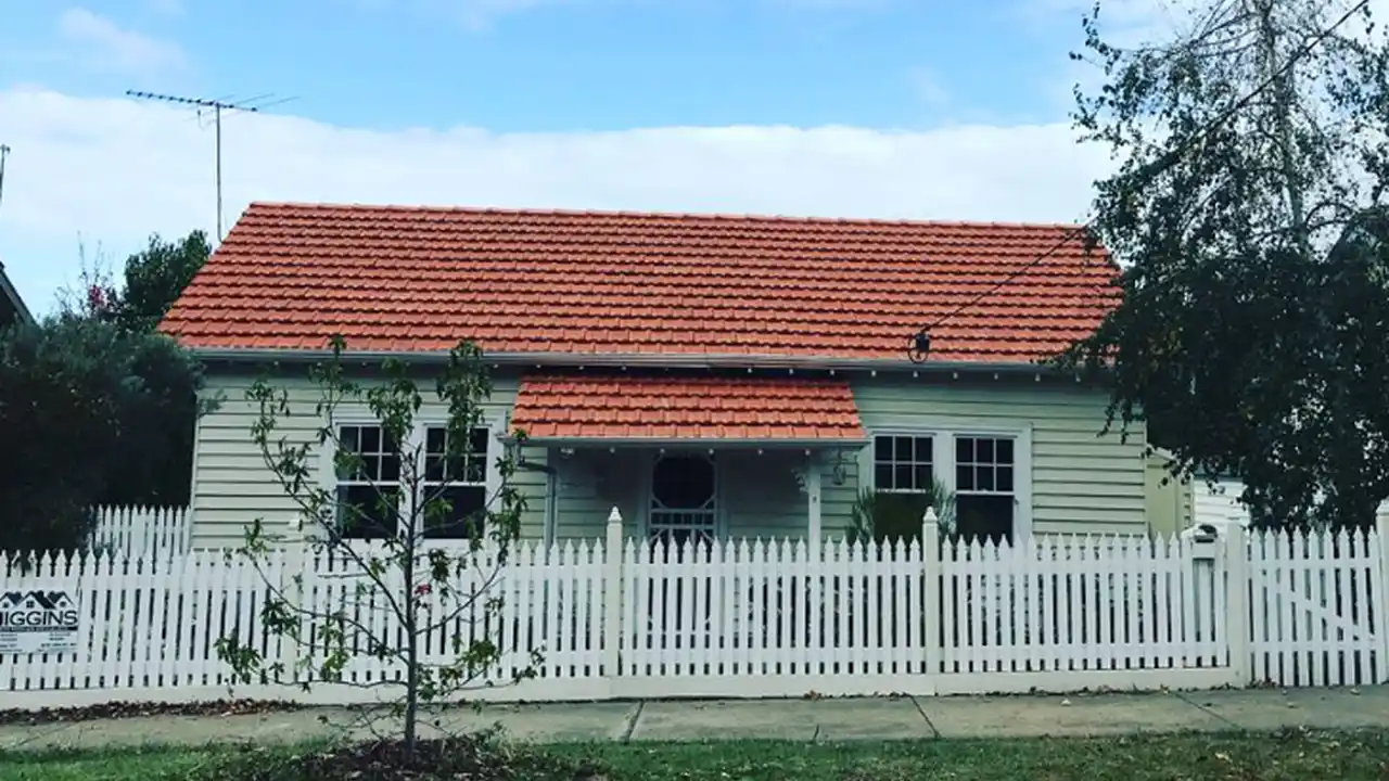 Close up on a plate of mashed potatoes, topped with baked pork chops with cream of mushroom soup, and a side of green beans.