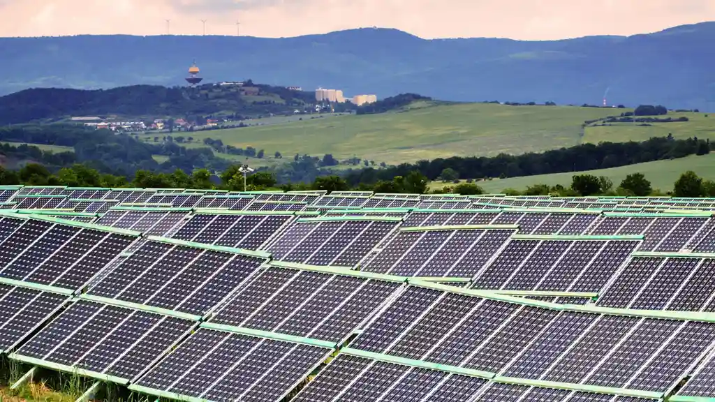 Close up on a plate of mashed potatoes, topped with baked pork chops with cream of mushroom soup, and a side of green beans.